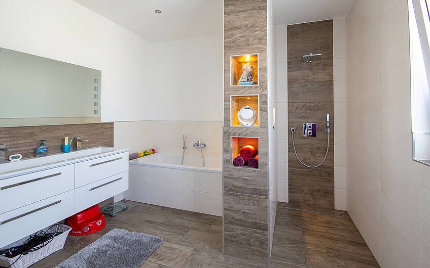Bad mit offener Dusche, Badewanne, Doppelwaschtisch und Trockenbaufächern in Kern-Haus Signus in Halle