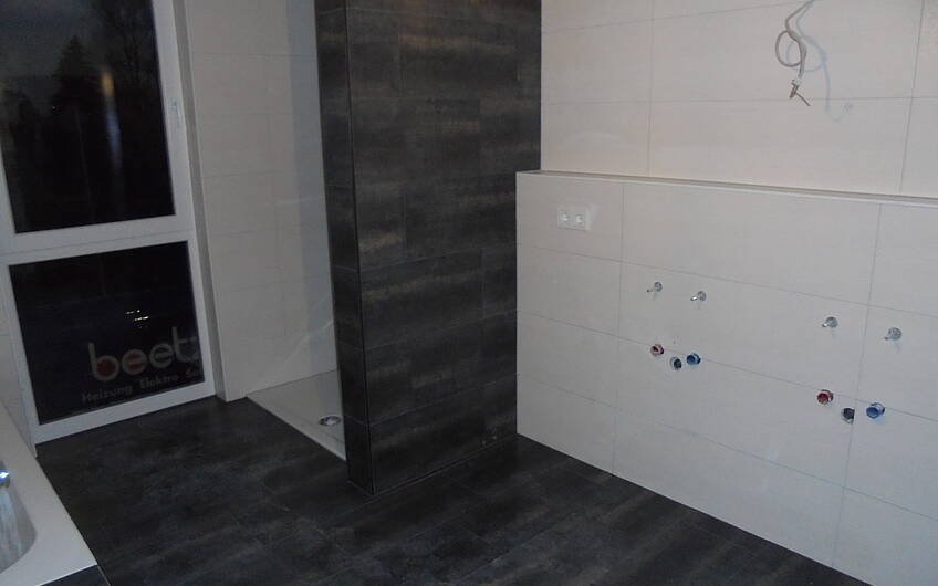 Gefliester Dusch- und Waschtischbereich im Badezimmer des frei geplanten Kern-Hauses in Zweibrücken