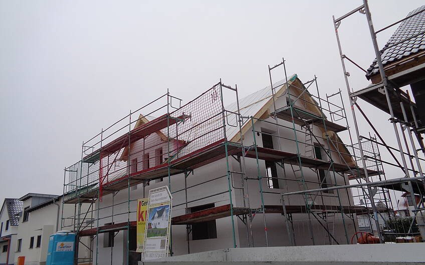 Rohbau des frei geplanten Einfamilienhauses von Kern-Haus in Römerberg mit Dachstuhl und Dachfolie