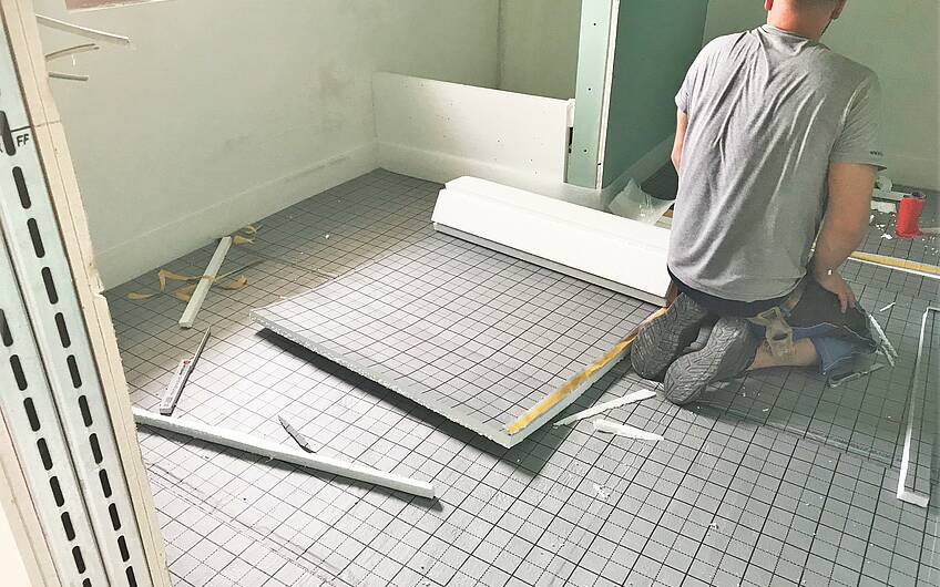 Arbeiter legt Fußbodendämmung in einem Kern-Haus aus