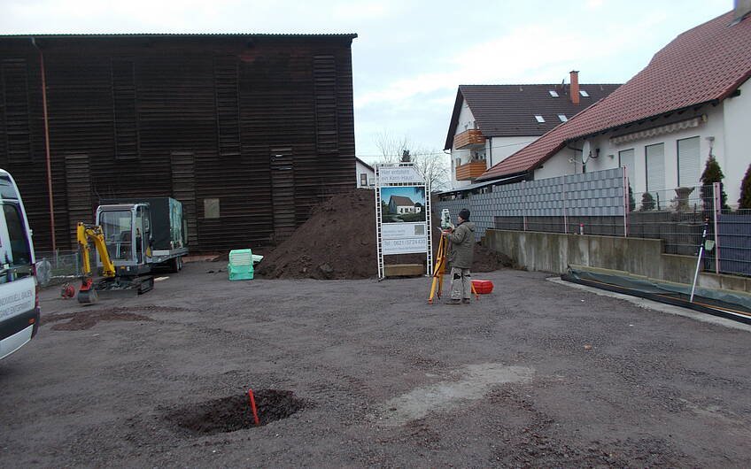 Grundstück in Hatzenbühl für das individuell geplante Familienhaus Luna von Kern-Haus mit Baustellenschild und Bagger