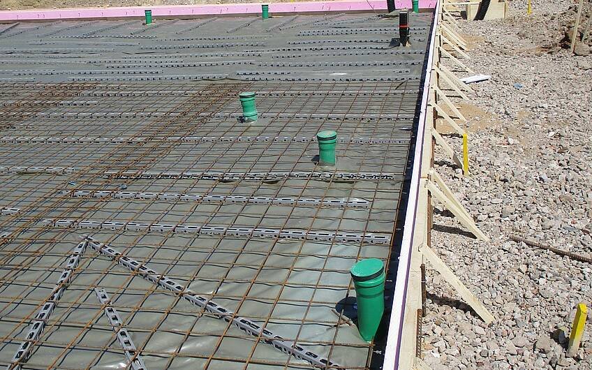 Durch die Schalung der Bodenplatte wird verhindert, dass Beton aus seiner Begrenzung der vorgegebenen Maße fließt.