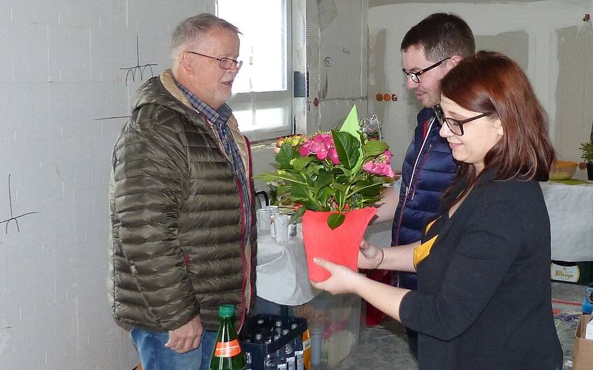 Bauherrin nimmt Blumen von Gast auf dem Rohbaufest in Einselthum entgegen.