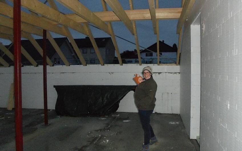 Bauherrin mit Nachwuchs im Dachgeschoss des Rohbaus in Obrigheim