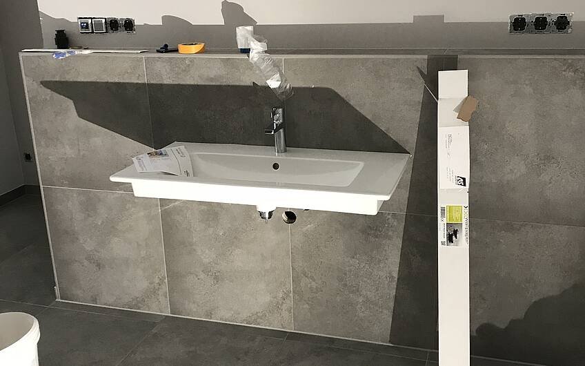 Montage des Waschbeckens im Badezimmer des frei geplanten Einfamilienhauses von Kern-Haus in Bissersheim