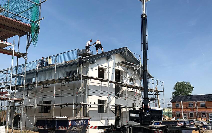 Arbeiter decken Dach des Architektenhauses Allea von Kern-Haus