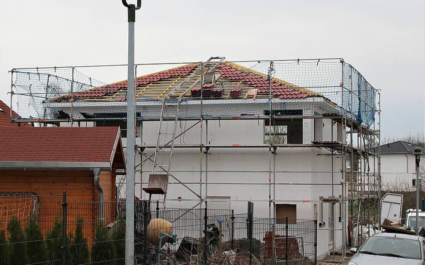 Die Handwerker decken das Dach ein. Die Stadtvilla in Magdeburg erhält rote Ziegel.