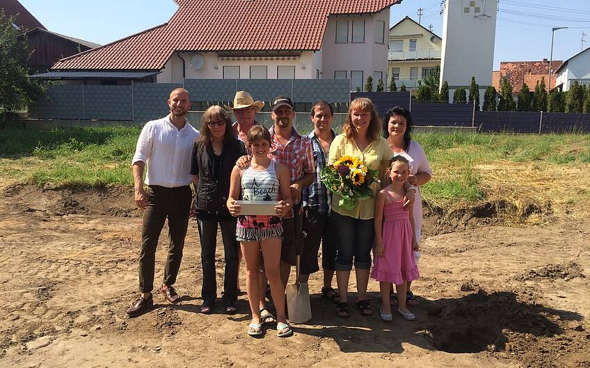Baufamilie mit Verkaufsberater Bernd Laatz bei der Grundsteinlegung für das Kern-Haus Luna in Hatzenbühl