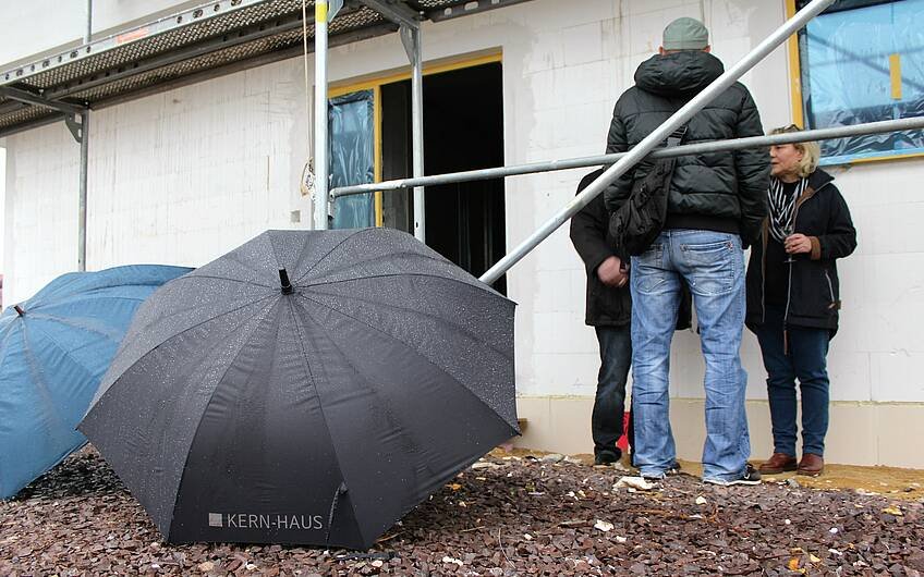 Regenschirme liegen aufgespannt vor dem Rohbau von Kern-Haus Magdeburg.