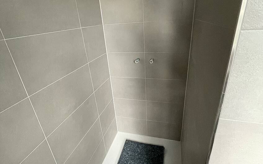 Die Duschtasse ist eingebaut und die Wände verfugt.