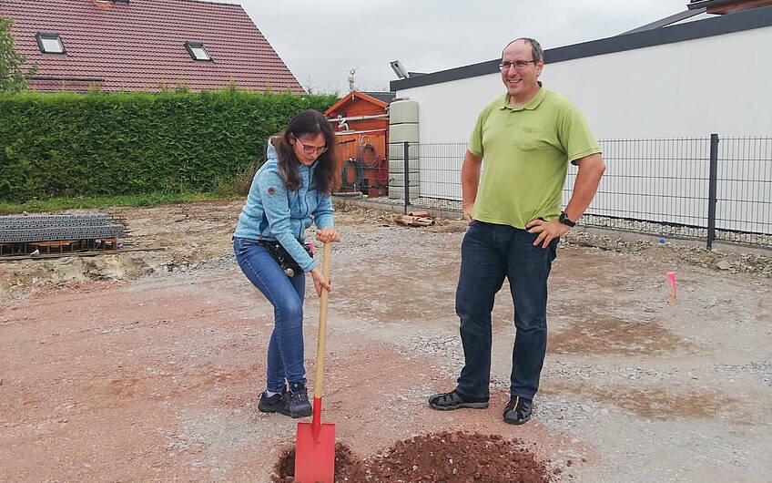 Bauherrin mit Bauherr beim Ausgraben des Loches für Grundsteinkassette für Kern-Haus in Halle Wörmlitz