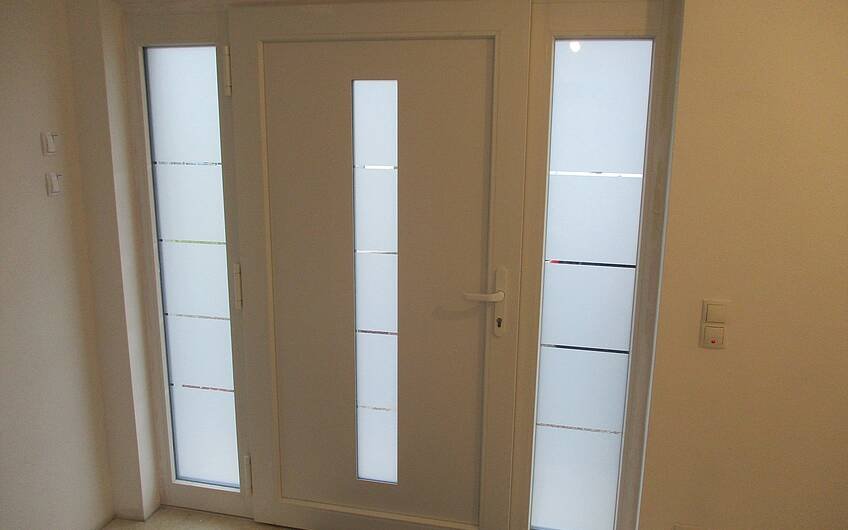 Die Haustür bietet Sicherheit. Glaselemente sorgen für optimale Lichteffekte im Flur.
