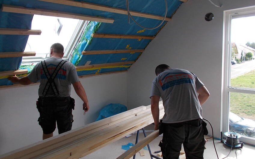 Trockenbauteam bei der Arbeit im Dachgeschoss des Familienhauses Signum von Kern-Haus in Einselthum