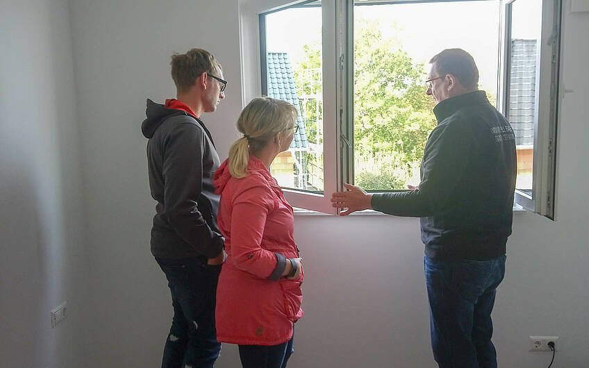 Bauleiter erklärt Bauherren die Fenster in Kern-Haus Rohbau in Weißenfels
