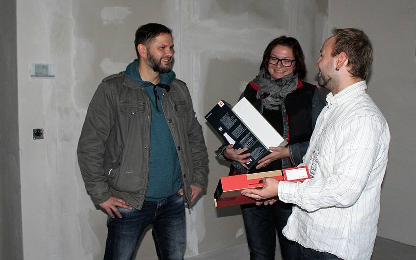 Yves Balster, Bauleiter von Kern-Haus, übergibt den Bauherren einen Dübelkoffer der Firma Würth.