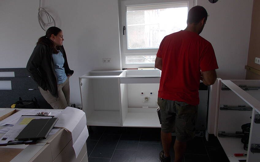 Bauherrin und Handwerker beim Einbau der Küche des frei geplanten Einfamilienhauses von Kern-Haus in Römerberg