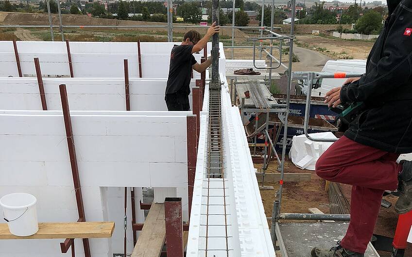 Arbeiter hält Betonpumpe für die Wände eines Kern-Hauses