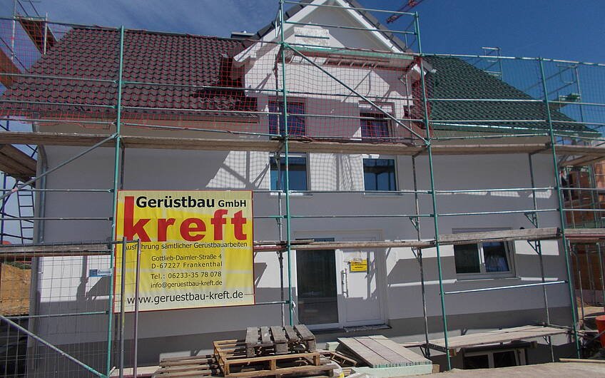 Eingangsseite des individuell geplanten Einfamilienhauses von Kern-Haus in Römerberg mit fertig verputzter Außenfassade