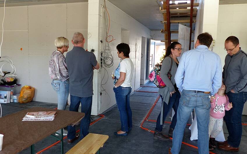 Gäste im Gespräch bei der Rohbaubesichtigung der frei geplanten Kern-Haus-Stadtvilla in Jockgrim