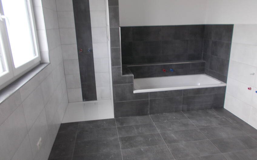 Geflieste Dusche und Badewanne im Badezimmer der Stadtvilla Signus in Dettenheim