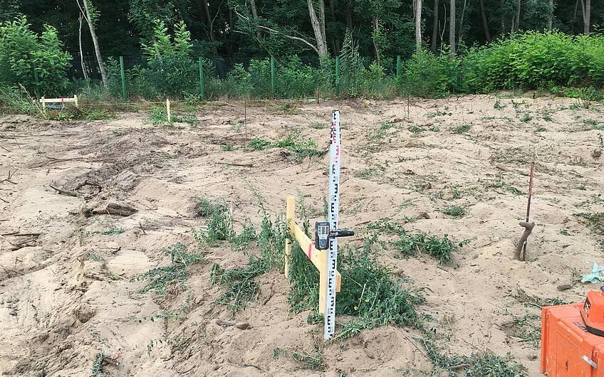 Das Grundstück in Biederitz wird mithilfe eines Nivilliergerätes vermessen.