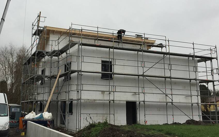 Dachziegel werden auf Kern-Haus-Rohbau Futura Pult gelegt