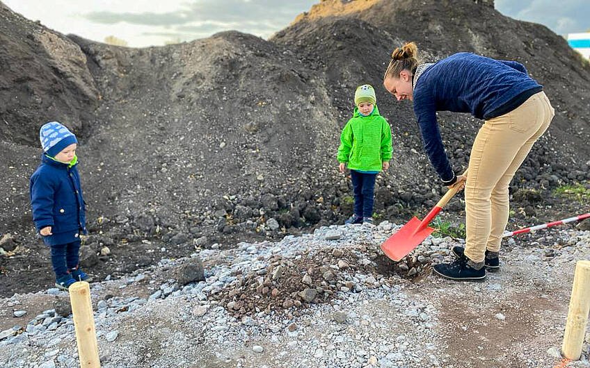 Bauherrin und Kinder helfen beim Ausheben des Loches für Grundsteinlegung eines Kern-Haus Gredo in Halle Reideburg