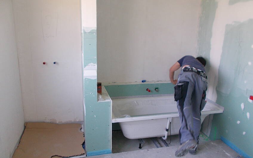 Installateur beim Einbau der Badewanne in der individuell geplanten Kern-Haus-Stadtvilla Signus in Dettenheim-Rußheim
