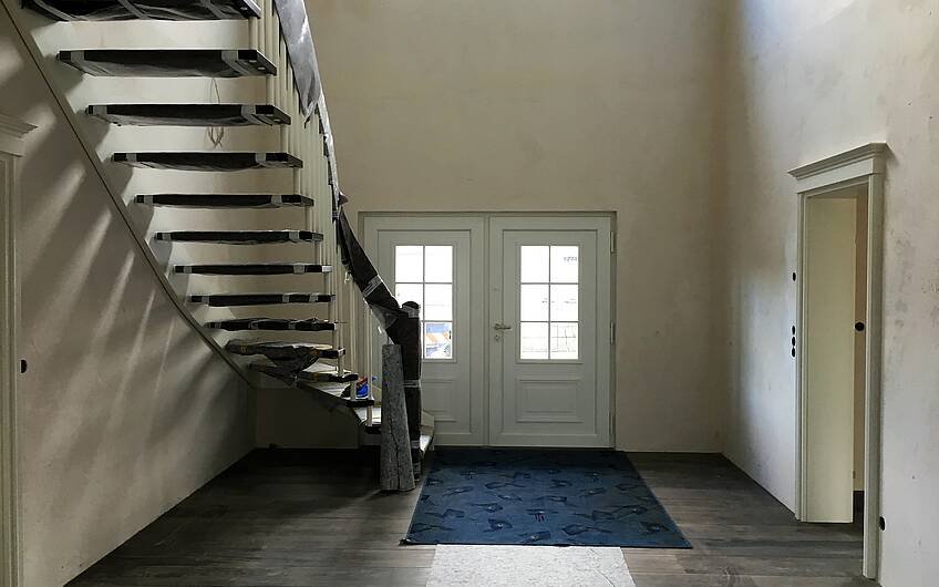 Eine edle Treppe schmückt den Eingangsbereich der Stadtvilla in Biederitz - ein Bauprojekt von Kern-Haus Magdeburg!