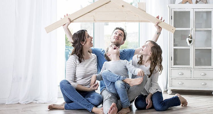 Familie auf Boden mit Holzdach
