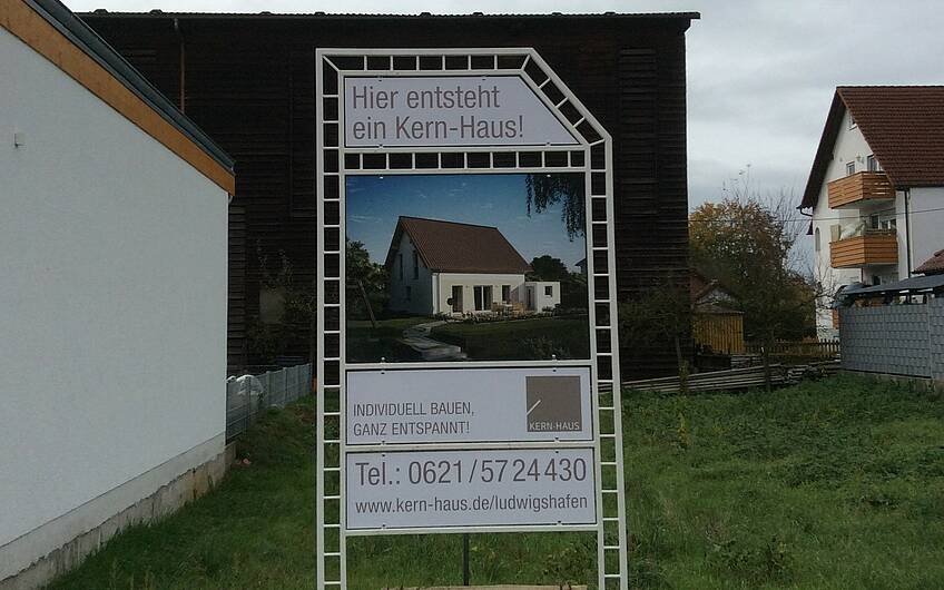 Bauschild mit Ankündigung des neuen Kern-Hauses Luna auf dem Grundstück in Hatzenbühl