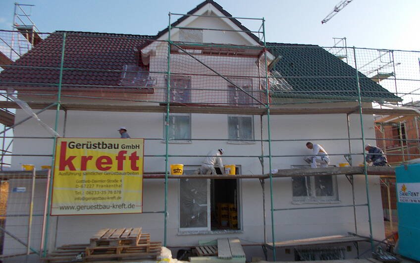 Außenputzteam bei der Arbeit auf der Eingangsseite des individuell geplanten Einfamilienhauses von Kern-Haus in Römerberg