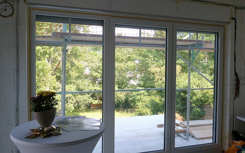 Wohnzimmerfenster des frei geplanten Kern-Hauses in Bad Dürkheim mit Blick in den Garten 