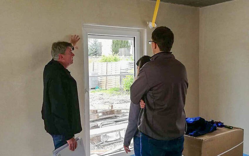 Bauleiter bei Erklärung der Fenster gegenüber Bauherren in Kern-Haus Rohbau in Halle Ammendorf