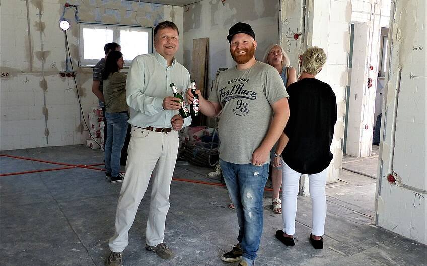 Bernd Vogt und Bauherr stoßen beim Rohbaufest im Architektenhaus Luna in Hatzenbühl an