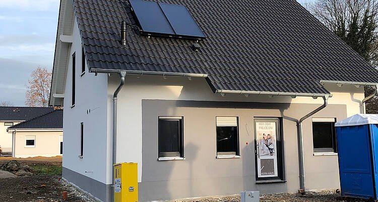 Eingangsseite des Kern-Haus Luna mit grauem Außenputz in Eilenburg