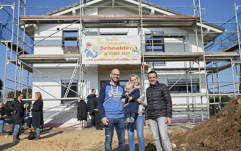 Die glückliche Bauherrenfamilie mit Verkaufsberater Thorsten Hoppen.