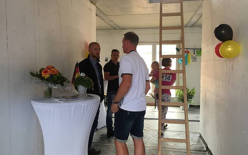 Verkaufsberater Bernd Laatz beim Rohbaufest in der Kern-Haus-Stadtvilla Signus in Otterberg im Gespräch mit einem Gast