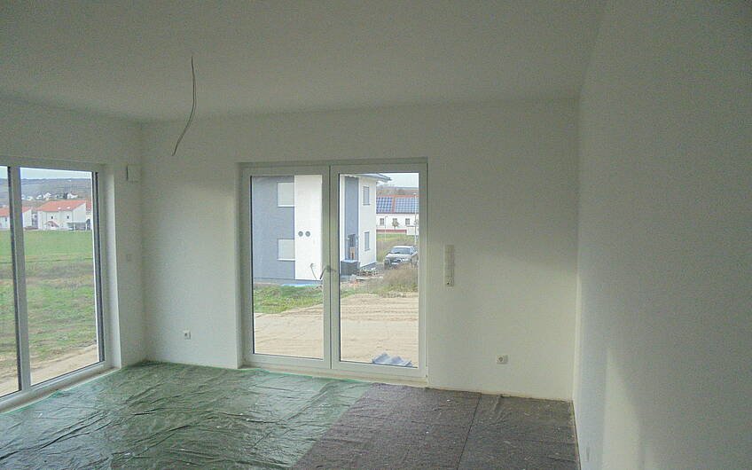 Wohnzimmer im individuell geplanten Einfamilienhaus Futura Pult von Kern-Haus in Obrigheim mit fertig tapezierten und gestrichenen Wänden