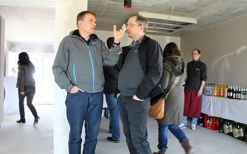 Nico Doberenz, Bauleiter von Kern-Haus Magdeburg (rechts im Bild), im Gespräch mit einem interessierten Besucher.
