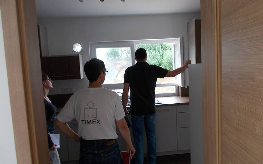 TÜV-Mitarbeiter und Bauherren in der Küche des individuell geplanten Einfamilienhauses Signum von Kern-Haus in Römerberg