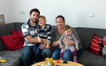 Baufamilie auf der Couch im Wohnzimmer des Kern-Hauses Komfort in Linkenheim-Hochstetten