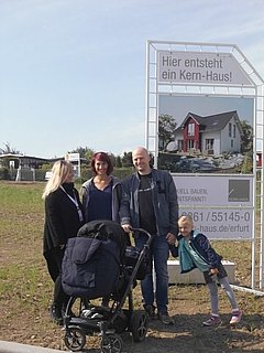 Bauherren vor Bauschild mit dem Kern-Haus Aura Baugebiet Erfurt-Marbach