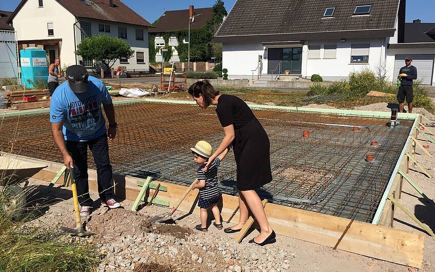 Bauherren mit Nachwuchs bei der Grundsteinlegung für das individuell geplante Einfamilienhaus Komfort von Kern-Haus in Neupotz