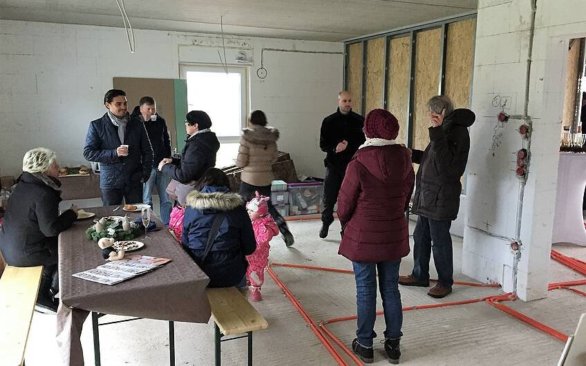 Gäste im Wohn- und Esszimmer bei der Rohbaubesichtigung im individuell geplanten Einfamilienhaus Luna von Kern-Haus in Albersweiler