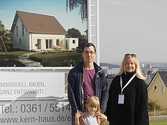 Bauherren vor Bauschild mit dem Kern-Haus Luna Baugebiet Erfurt-Marbach