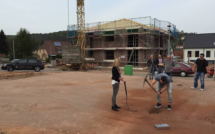 Bauherr mit Spitzhacke bei der Grundsteinlegung für die Kern-Haus-Stadtvilla Signus in Otterberg