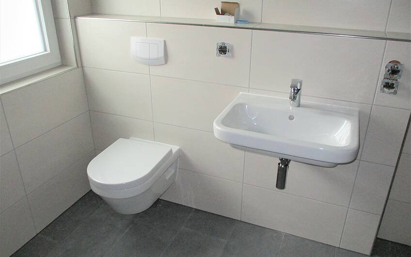  Die modernen Sanitärobjekte wie Waschbecken und Toilette wurden montiert.