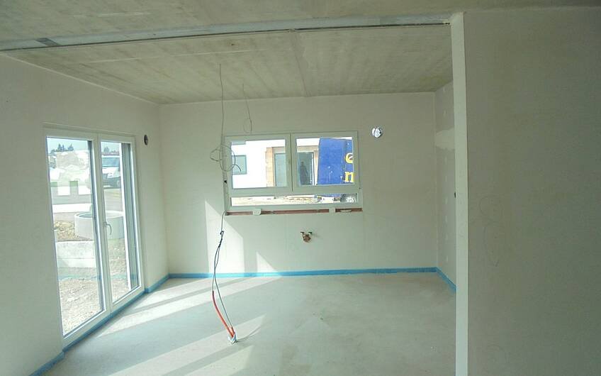 Wohn-Essbereich der Kern-Haus-Stadtvilla Signus in Obrigheim mit verputzten Wänden und verlegtem Estrichboden