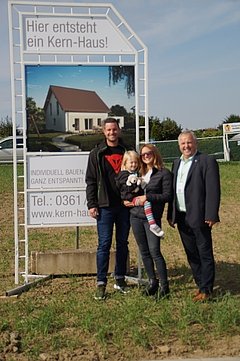 Bauherr vor Bauschild mit dem Kern-Haus Luna Baugebiet Erfurt-Marbach
